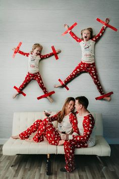 two people in matching pajamas are sitting on a couch