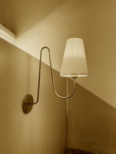 a wall light with a white shade on it