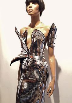 a mannequin wearing a silver dress with an unusual design on it's chest