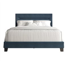 a bed with white sheets and blue headboard