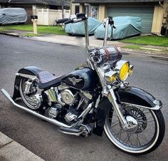 the motorcycle is parked on the side of the road in front of some houses and cars