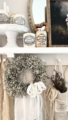 two white shelves with wreaths and other items on them