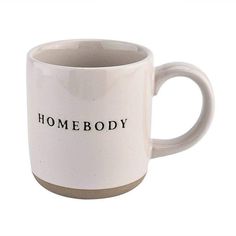 a white coffee mug with the words home body printed on it's front and side