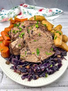 a white plate topped with meat and vegetables