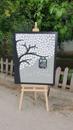 an easel with a wedding guest sign on it sitting in front of a fence