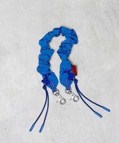 two blue lanyards tied together on a white surface