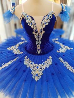 a blue and white ball gown on display in a store window, with beaded detailing