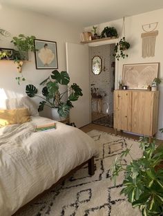 a bed room with a neatly made bed and lots of plants