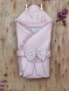 a pink robe and bow tie laying on top of a wooden floor