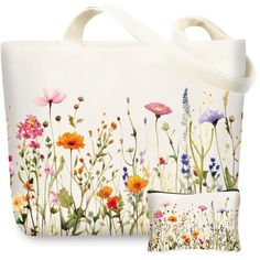 a white bag with flowers painted on the front and side, sitting next to it