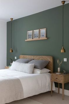 a bedroom with green walls and white bedding