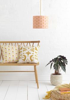 a wooden bench sitting next to a potted plant on top of a white floor