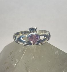 Claddagh ring pink ice marcasites love heart friendship sterling silver women girls Size 6.50Weight 2.7g Widest part   1/2"Thinnest part of band 1/8"Free Shipping & Free Postal InsuranceDelivered in a Gift BoxIf you do not want the ring polished and want to leave the natural patina please let me know at the time of purchase as I do polish rings before I ship rings out. ThanksFree First Class shipping and postal insurance is included. If you want to upgrade to priority kindly pay an additiona Silver Amethyst Ring For Valentine's Day Gift, Pink Amethyst Ring In Sterling Silver For Anniversary, Adjustable Pink Heart Ring For Promise, Pink Adjustable Heart Ring For Promise, Silver Heart-shaped Adjustable Crystal Ring, Adjustable Silver Heart-shaped Crystal Ring, Valentine's Day Pink Sterling Silver Birthstone Ring, Sterling Silver Amethyst Ring For Valentine's Day, Pink Sterling Silver Ring With Stone Setting