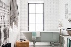 a bathroom with a tub, sink and towel rack on the wall next to it