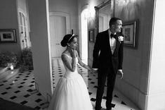 the bride and groom are walking through the hallway together in black and white photoboot