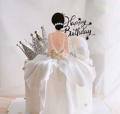 a birthday cake with a woman's dress and tiara sitting on top of it