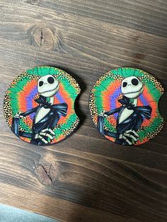 two coasters that have been painted to look like jack skellingy and the skeleton is