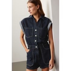 Blue denim (100% Cotton). Romper. Short sleeves. Collared. Front button closure. 32.5" from shoulder to hemline. 9" inseam. Imported. Summer Denim Jacket For Workwear, Summer Denim Jacket For Work, Collared Denim Jumpsuit With Button Closure, Short Sleeve Denim Vest With Pockets, Dark Wash Denim Top For Work With Button Closure, Dark Wash Denim Top For Workwear, Denim Vest With Pockets And Short Sleeves, Blue Denim Jacket For Summer Workwear, Indigo Denim Top With Button Closure