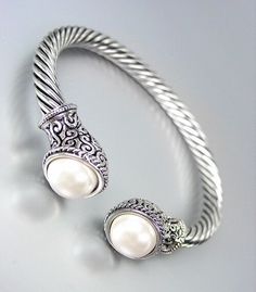 UNIQUE Silver Cable White Pearl BALINESE Filigree End Tips Cuff Bracelet UNIQUE Silver Cable White Pearl BALINESE Filigree End Tips Cuff Bracelet Click images to enlarge Description UNIQUE Silver Cable Pearl BALINESE Filigree End Tips Cuff Bracelet     Unique Style!  Intricately crafted with detailed Balinese filigree & pearl end tips, this unique silver cable cuff bracelet looks classic & elegant.  It comfortably adjusts to fit all size wrists and can be worn alone or combined with you other de Jewelry Design Inspiration, Trendy Fashion Jewelry, Christmas 2014, Antique Metal, Classic Elegant, Balinese, White Pearl, Pandora Charm Bracelet, Pearl White