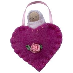 a pink heart shaped bag with a stuffed animal in it's center and a rose on the side