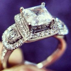 a close up of a diamond ring on someone's finger