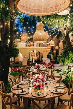 an outdoor dining area with wooden chairs and tables set up for a meal, surrounded by greenery