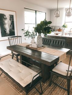 a dining room table with four chairs and a bench