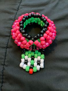 three bracelets with different colored beads on a black surface