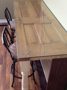 a wooden table with chairs around it on top of a hard wood floor next to a wall