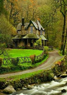 a house sitting next to a river in the woods