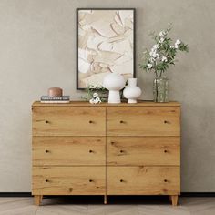 a wooden dresser with vases and flowers on top