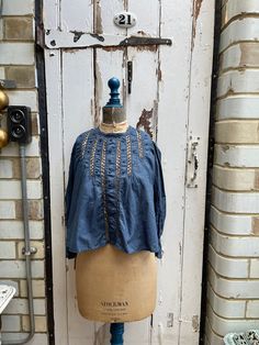 Antique French blue cotton blouse size XS UK 8. 100% Cotton. Dyed dark blue. Round neck, lace panels and embroidered dots on front and at cuffs, handgathering at shoulders, button thro at back - lovely detail. Size:  Chest: 34 inches; shoulder to shoulder: 13 inches; Sleeve length: 19 inches; cuff opening: 4.5 inches wide; Length: 18.5 inches Weight: allow up to 1 kg once packed. Good condition. Blue Lace Trim Top For Fall, Blue Lace Trim Tops For Fall, Festival Cotton Tops With Buttons, Cotton Festival Tops With Buttons, Bohemian Denim Blue Tops For Fall, Vintage Indigo Tops For Fall, Vintage Indigo Top For Fall Season, Vintage Indigo Top For Fall, Blue Lace Trim Blouse For Fall