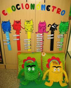 two stuffed animals sitting next to each other in front of a bulletin board