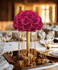 the centerpieces on this table are adorned with gold chains and pink roses,