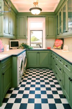 a kitchen with green cabinets and black and white checkered flooring on the tile