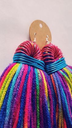 a pair of multicolored earrings hanging from a hook