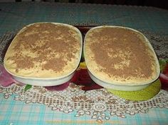 two pans filled with food sitting on top of a lace tablecloth covered table