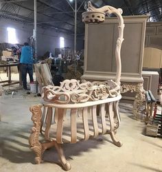 there is a bench made out of wood in the middle of a room with people working on it