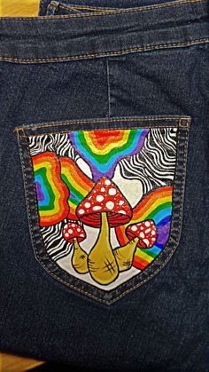 the back pocket of a pair of jeans with an image of mushrooms and rainbows on it