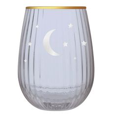 a clear glass with a gold rim and white stars on the side, sitting in front of a white background