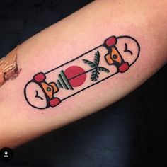 a person with a tattoo on their arm has a skateboard in the shape of a bomb