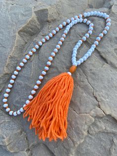 great boho chic style  tassel necklace  white  wooden beads (8mm) spaced by orange wooden beads  orange wooden barrel bead  & an extra fluffy handmade,  orange, 100% cotton tassel charm  This necklace measure 34 inches.  (17  inches both sides)     Total hanging length from nape of neck to end of tassel is 22 inches. tassel is 4"  If you would like a different length, just message me 😀 Please take a few moments to browse through my shop.  I have a large selection of unique belt bucks, leather b White Wooden Beads Necklace For Meditation, White Beaded Tassel Necklaces As Gift, White Beaded Necklaces With Tassels For Gift, White Round Beaded Tassel Jewelry, White Tassel Jewelry With Round Beads, White Beaded Necklaces With Tassels As Gift, White Bohemian Beaded Necklace With Tassels, Adjustable White Tassel Necklace Gift, White Beaded Bohemian Tassel Necklace