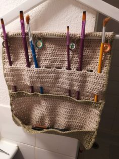 a crocheted toothbrush holder hanging on the wall