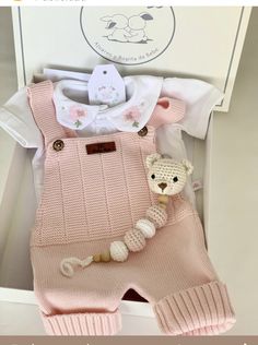 a pink knitted outfit with a teddy bear on it