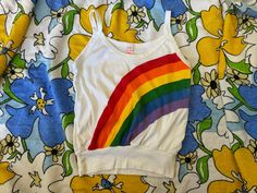 Vintage 70s 80s Rainbow tank top, Joey Ey Joe Joey tank top 1970s 1980s, vintage rainbow clothing, retro rainbow top Joey Ey Joe Joey rainbow tank top! from the 70s/80s made in the USA 50% polyester, 50% acrylic stated size large but please always go by measurements for best fit Faded line marks on rainbow in sort of a square shape, some faded marks on back. Measurements:  17" bust or 34" doubled it does stretch 17.5" top of shirt to bottom of shirt not including strap 21" top of strap to bottom of shirt 12" flat across bottom band of tank top- it does stretch **PLEASE SEE PICTURES FOR CONDITION, IF YOU NEED MORE ASK** Retro Multicolor Tops With Rainbow Print, Playful Rainbow Print Top, Retro Multicolor Tank Top, 80s Tank Top, Rainbow Clothing, 1970s Vintage Print Tops, Rainbow Tank Top, Rainbow Top, Rainbow Outfit