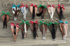 several horses are tied up to string with red and green bows on them, sitting on a wooden surface