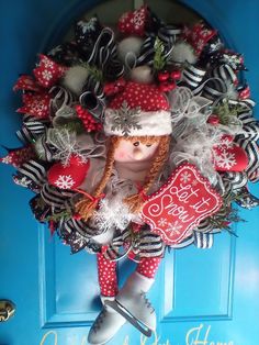 a christmas wreath with a doll in it on a blue front door and the words happy new year