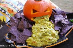 a plate with chips, guacamole and a jack - o'- lantern