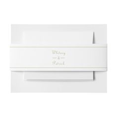 two folded white envelopes with gold foil lettering