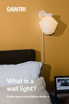 a lamp that is on top of a bed next to pillows and a framed photograph